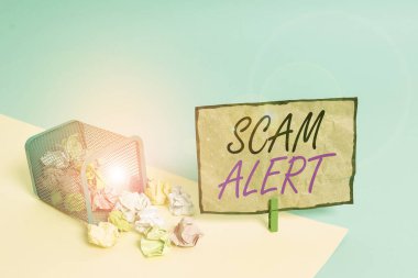 El yazısı yazıları Scam Alert. Konsept, birini dolandırıcılık ya da entrika hakkında uyarmaktır. Çöp tenekesi buruşmuş kağıt mandalları boş hatırlatma bürosu malzemeleri..