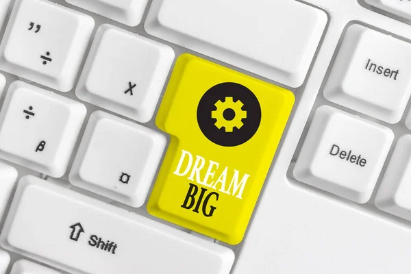 Konceptuell handstil som visar Dream Big. Business photo showcasing Att tänka på något högt värde som du vill uppnå White pc tangentbord med not papper ovanför den vita bakgrunden. — Stockfoto