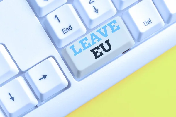 Handwriting text Leave Eu. Concept meaning An act of a demonstrating to leave a country that belongs to Europe White pc keyboard with empty note paper above white background key copy space.