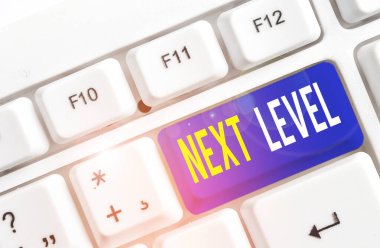 Sonraki Seviye 'yi gösteren metin işareti. Birden fazla kata sahip olan kavramsal fotoğraf ve beyaz arkaplan anahtar alanının üzerinde boş not kağıdıyla birlikte geçerli White pc klavyesinden alıntı.