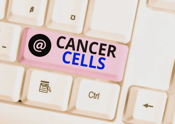 Написание текста "Раковые клетки". Бизнес-концепция для формирования твердых опухолей или заполнения крови аномальными клетками Белая компьютерная клавиатура с пустой бумагой на белом фоне . — стоковое фото