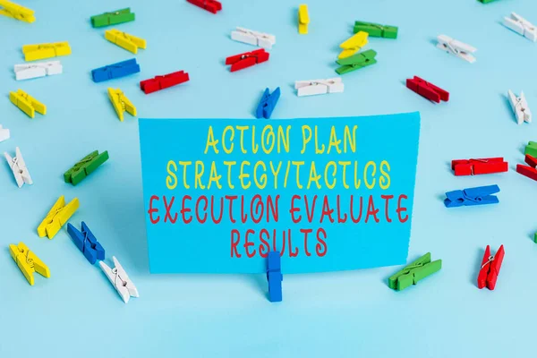 Handwriting text Action Plan Strategy Ortacti. Concept meaning Action Plan Strategy Or Tactics Execution Evaluate Results Colored clothespin papers empty reminder blue floor background office pin.