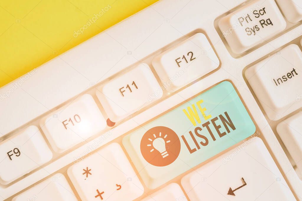 Conceptual hand writing showing We Listen. Business photo showcasing Group of showing that is willing to hear anything you want to say White pc keyboard with note paper above the white background.