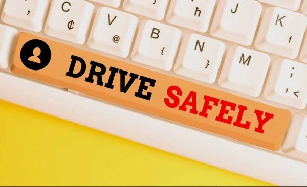 Text sign showing Drive Safely. Conceptual photo you should follow the rules of the road and abide laws White pc keyboard with empty note paper above white background key copy space.