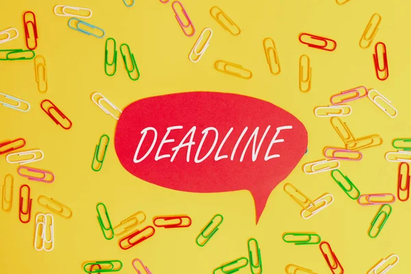 Handwriting text Deadline. Concept meaning Period of time by which something must be finished or accomplished Flat lay above empty paper with copy space and colored paper clips.