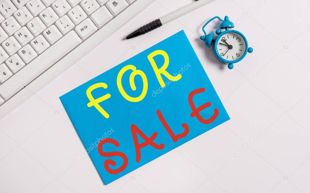 Writing note showing For Sale. Business photo showcasing putting property house vehicle available to be bought by others Flat lay above empty note paper on the pc keyboard pencils and clock.