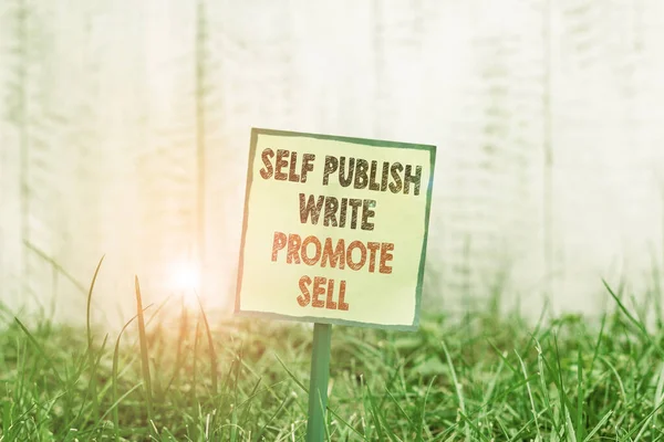 Концептуальное рукописное написание, показывающее Self Publish Write Promote Sell. Деловое фото, демонстрирующее автопромоушен написание маркетинговой рекламы Простая бумага прилагается к палочке и размещены в травянистой земле . — стоковое фото