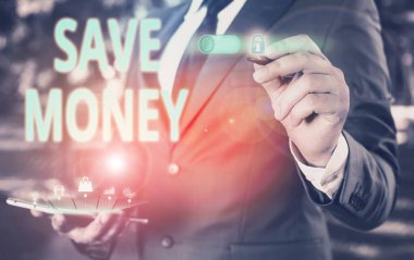 Tasarruf Parasını gösteren metin işareti. Kavramsal fotoğraf dükkânı. Paranızın bir kısmı her ay onları kullanmak için kullanılıyor. Bir süre sonra erkek giyimi giyip sunum yaparken akıllı aygıt kullanılıyor..