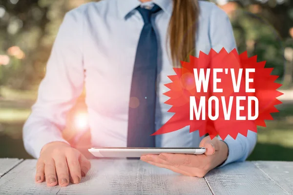 Texto de escritura de palabras We Ve Moved. Concepto de negocio para ir a vivir desde el lugar de otro mismo o diferente país Mujer de negocios sentada junto a la mesa y sosteniendo el teléfono móvil . — Foto de Stock