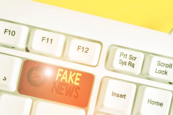 Signo de texto que muestra noticias falsas. Foto conceptual Dar información para mostrar que no es cierto por los medios Teclado de PC blanco con papel de nota vacío sobre el espacio de copia de la tecla de fondo blanco . — Foto de Stock