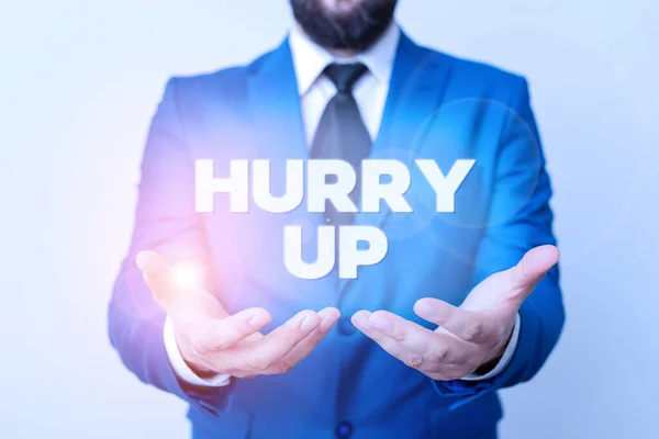 Text sign showing Hurry Up. Conceptual photo asking someone to do a job very fast Quickly Lets go Encourage Man with opened hands in fron of the table. Mobile phone and notes on the table.