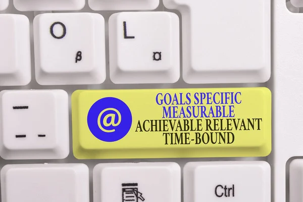 Writing note showing Goals Specif Measureable AC. Business photo showcasing Goals Specific Measurable Achievable Relevant Time Bound White pc keyboard with note paper above the white background. — Stock Photo, Image