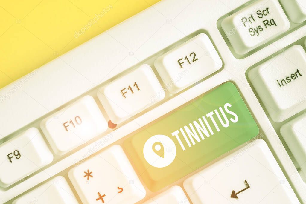 Text sign showing Tinnitus. Conceptual photo A ringing or music and similar sensation of sound in ears White pc keyboard with empty note paper above white background key copy space.