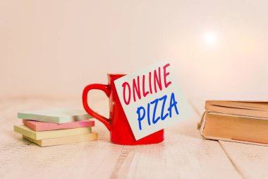 Çevrimiçi Pizza 'yı gösteren mesaj işareti. Kavramsal fotoğraf kapınızda pizza teslimatı çevrimiçi yemek siparişi kahve fincanı boş not defteri eski ahşap masa..