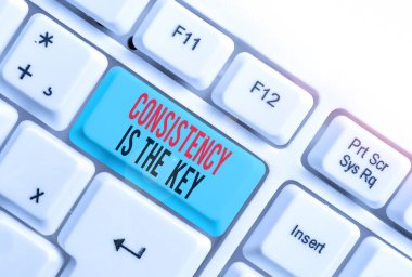 El yazısı tutarlılığı anahtardır. Bir göreve tam adanmışlık anlamına gelen kavram bir alışkanlık oluşturma süreci beyaz arkaplan üzerindeki boş not kağıdıyla beyaz pc klavye anahtar boşluğu.