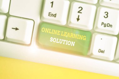 Çevrimiçi Öğrenme Çözümünü gösteren bir not yazıyorum. Eðitim Müfredatýna Elektronik eriþimin iþletme fotografý beyaz altyapýsý üzerinde not kağıdı olan beyaz pc klavyesine eriþimi.