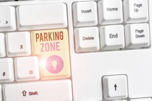 Текст для написання слів Паркувальна зона. Бізнес-концепція простору, де автомобіль може бути припаркований Дозволяється припаркована біла клавіатура ПК з порожнім папером нотатки над білим фоновим ключем копіювання простору . — стокове фото