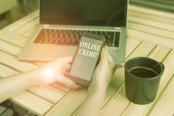 オンライン犯罪を示すメモを書く。ノートパソコンのスマートフォンやオフィス用品技術でインターネット女性に犯罪や違法オンライン活動を紹介するビジネス写真. — ストック写真