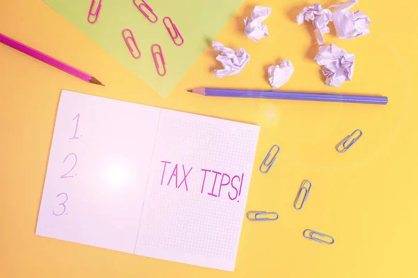 Tekst schrijven Tax Tips. Zakelijk concept voor verplichte bijdrage aan de overheidsinkomsten geheven door de overheid Blanco vierkant notebook potloden papier blad verpletterd ballen gekleurde achtergrond. — Stockfoto