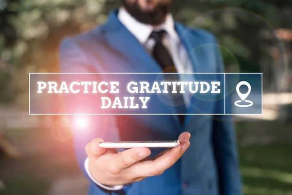 Handwriting text writing Practice Gratitude Daily. Concept meaning be grateful to those who helped encouarged you Businessman in blue suite stands with mobile phone in hands.