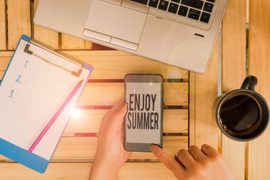 Yazın tadını çıkardığını gösteren kavramsal el yazısı. İş fotoğraflarına göre okula ara vermek ve tatillerini sahilde bilgisayar başında akıllı telefon ve ofis teknolojisiyle geçirmek..