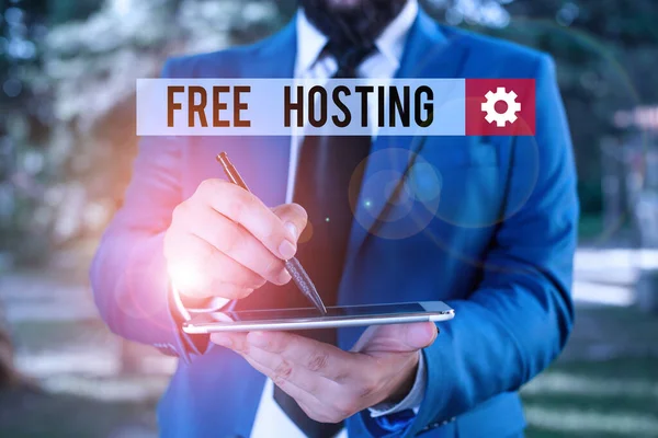 Text sign showing Free Hosting. Conceptual photo business of providing storage space and access for websites Businessman in blue suite stands with mobile phone in hands.