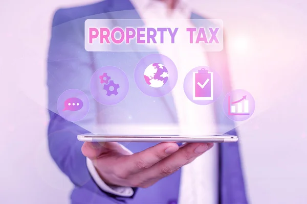 Writing note showing Property Tax. Business photo showcasing an ad valorem tax on the value of a property Millage rate Male human wear formal suit presenting using smart device.