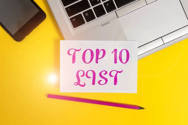 Tekstbord met Top 10 Lijst. Conceptuele foto de tien belangrijkste of succesvolle items in een bepaalde lijst Metallic laptop potlood kwadraat papier blad smartphone gekleurde achtergrond. — Stockfoto