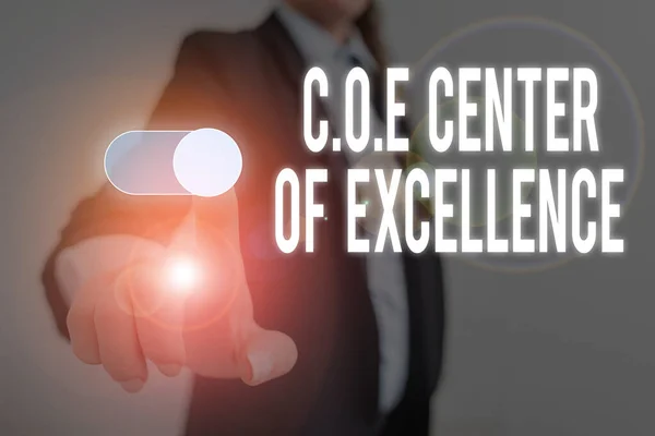 Word writing text Coe Center Of Excellence. Business concept for being alpha leader in your position Achieve Woman wear formal work suit presenting presentation using smart device.
