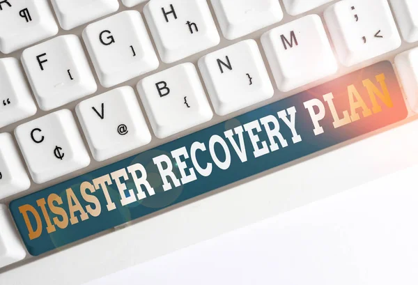 Text sign showing Disaster Recovery Plan. Conceptual photo having backup measures against dangerous situation White pc keyboard with empty note paper above white background key copy space.