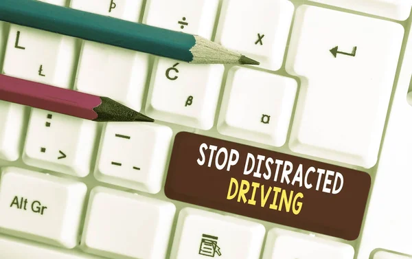 Conceptual hand writing showing Stop Distracted Driving. Business photo text asking to be careful behind wheel drive slowly White pc keyboard with note paper above the white background. — Stock Photo, Image