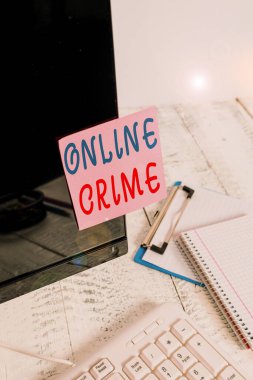 Çevrimiçi Suçları gösteren bir not yazıyorum. İnternet Not kağıdında klavye ve sabit bilgisayarın yanındaki siyah bilgisayar ekranına bantlanmış suç veya yasadışı online faaliyet gösteren iş fotoğrafları.