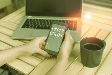 Order Online 'ı gösteren bir not yazıyorum. Bilgisayarlı akıllı telefon ve ofis teknolojisi ile internet üzerinden ürün veya hizmet satın almanın iş fotoğraflarının sergilenmesi.