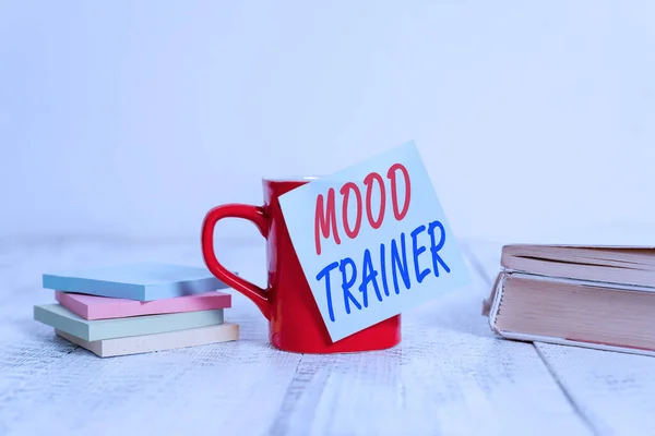 Textskylt som visar Mood Trainer. Konceptuell bild en demonstration som tränar för att lindra humörstörningar i en demonstration Kaffekopp tom klibbig ton staplade anteckningsblock böcker retro gammalt träbord. — Stockfoto