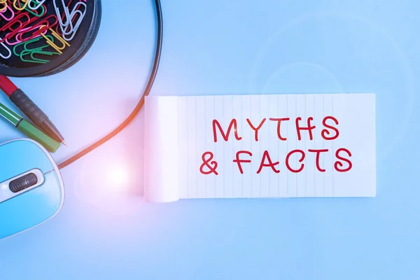 Handwriting text Myths And Facts. Concept meaning usually traditional story of ostensibly historical events Notebook and writing equipment with computer mouse above pastel backdrop. — Stock Photo, Image