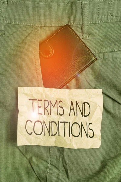 Word writing text Terms And Conditions. Business concept for rules that apply to fulfilling a particular contract Small little wallet inside man trousers front pocket near notation paper. — Stock Photo, Image