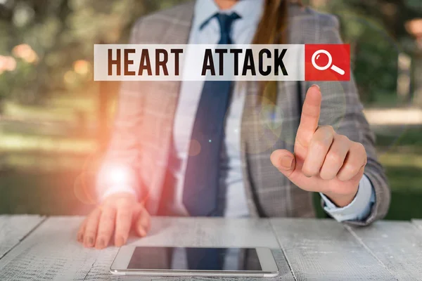 Texte d'écriture de mots Heart Attack. Concept d'entreprise pour survenue soudaine et parfois fatale de thrombose coronarienne Femme homme d'affaires assis à table tenant un téléphone portable . — Photo