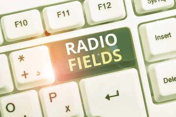 Conceptual hand writing showing Radio Fields. Business photo text electromagnetic field intensity consisting of an electric White pc keyboard with note paper above the white background.