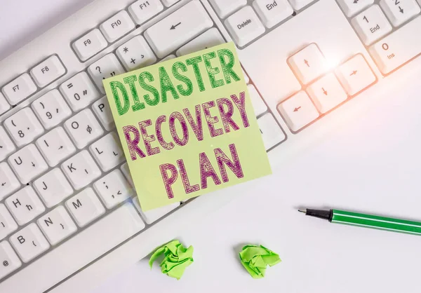 Writing note showing Disaster Recovery Plan. Business photo showcasing having backup measures against dangerous situation Green note paper with pencil on white background and pc keyboard.