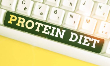 Protein diyetini gösteren bir not yazıyorum. İş fotoğraflarında düşük yağ ya da karbonhidrat tüketim zayıflama planı beyaz arka planda notalı beyaz pc klavye.