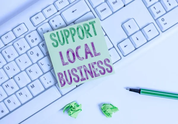 Writing note showing Support Local Business. Business photo showcasing increase investment in your country or town Green note paper with pencil on white background and pc keyboard.