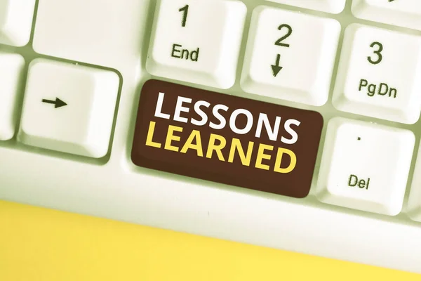 Conceptual hand writing showing Lessons Learned. Business photo text the knowledge or understanding gained by experience White pc keyboard with note paper above the white background.