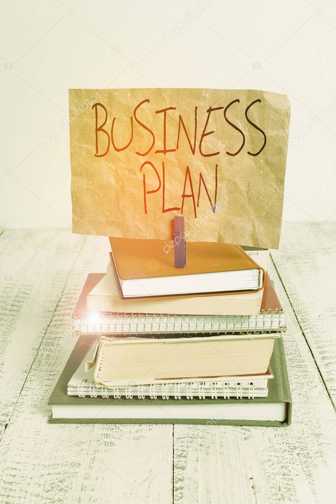 Writing note showing Business Plan. Business photo showcasing Structural Strategy Goals and Objectives Financial Projections pile stacked books notebook pin color reminder white wooden.