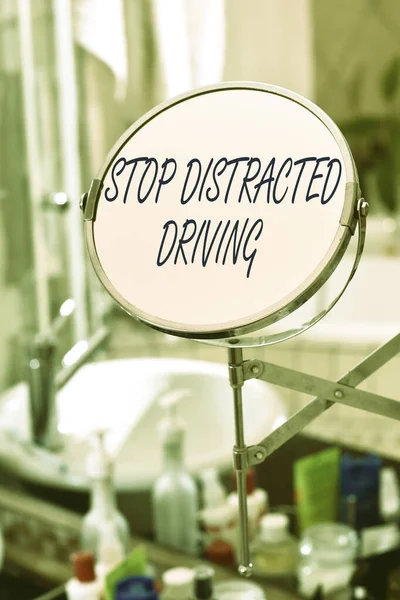 Manuscrito texto Stop Distracted Driving. Conceito que significa pedir para ter cuidado atrás da roda motriz lentamente Espelho de forma redonda e produtos de higiene pessoal colocados ao lado de afundar em um banheiro moderno . — Fotografia de Stock