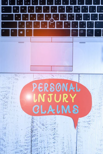 Word writing text Personal Injury Claims. Business concept for being hurt or injured inside work environment Close view open laptop blank speech bubble downwards lying vintage table.