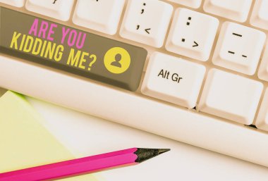 Text sign showing Are You Kidding Me Question. Conceptual photo Expression of Disbelief or could not be true White pc keyboard with empty note paper above white background key copy space.