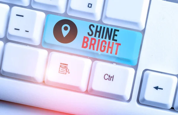 Text sign showing Shine Bright. Conceptual photo make an effort to live normally when in a difficult situation White pc keyboard with empty note paper above white background key copy space.