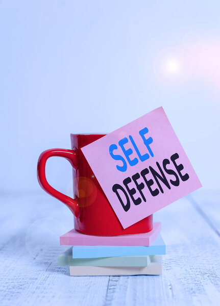 Handwriting text Self Defense. Concept meaning the act of defending one s is demonstrating when physically attacked Coffee cup blank sticky note stacked note pads retro retro wooden table.