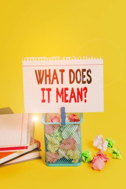 Handwriting text What Does It Mean Question. Concept meaning Give me the meaning of something Definition Trash bin crumpled paper clothespin empty reminder office supplies yellow. clipart