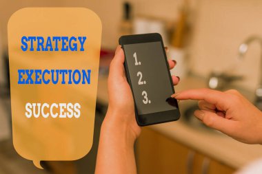 Strateji Uygulaması Başarı Raporu Yazılıyor. İş fotoğraflarının sergilenmesi plan ya da liste koymak ve bunu iyi yapmaya başlamak için akıllı telefon ve teknolojik cihazlar kullanan kadın ev içinde.